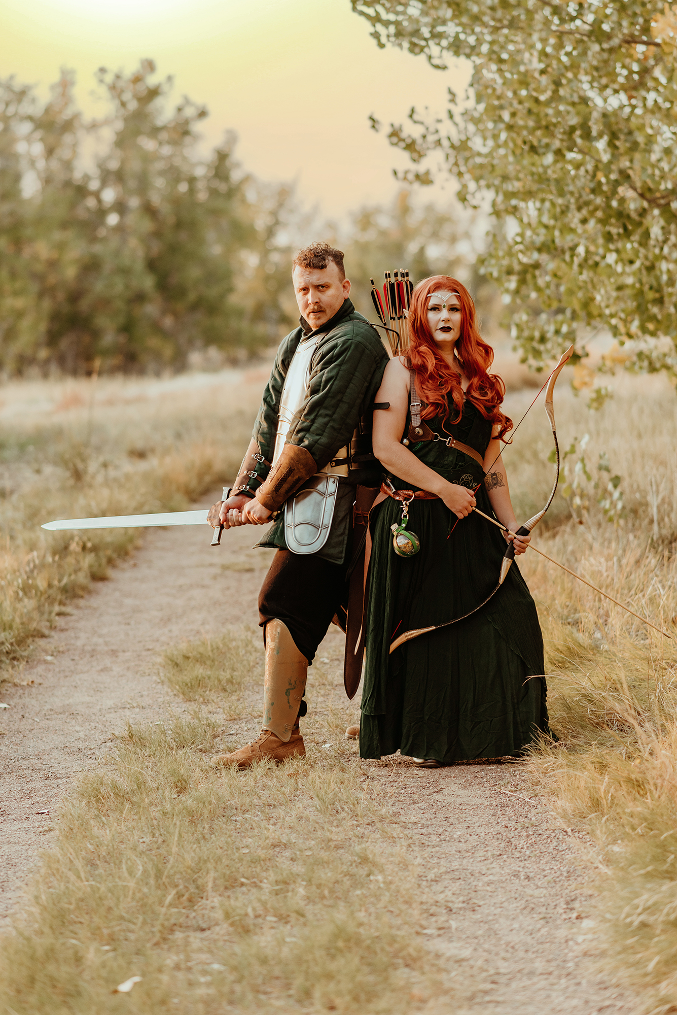 A portrait of a couple wearing fantasy cosplay costumes for unique family photos, Photo of a man wearing a knight's costume and a woman wearing an elven warrior costume pose for a photo by Kendra Colleen Photography