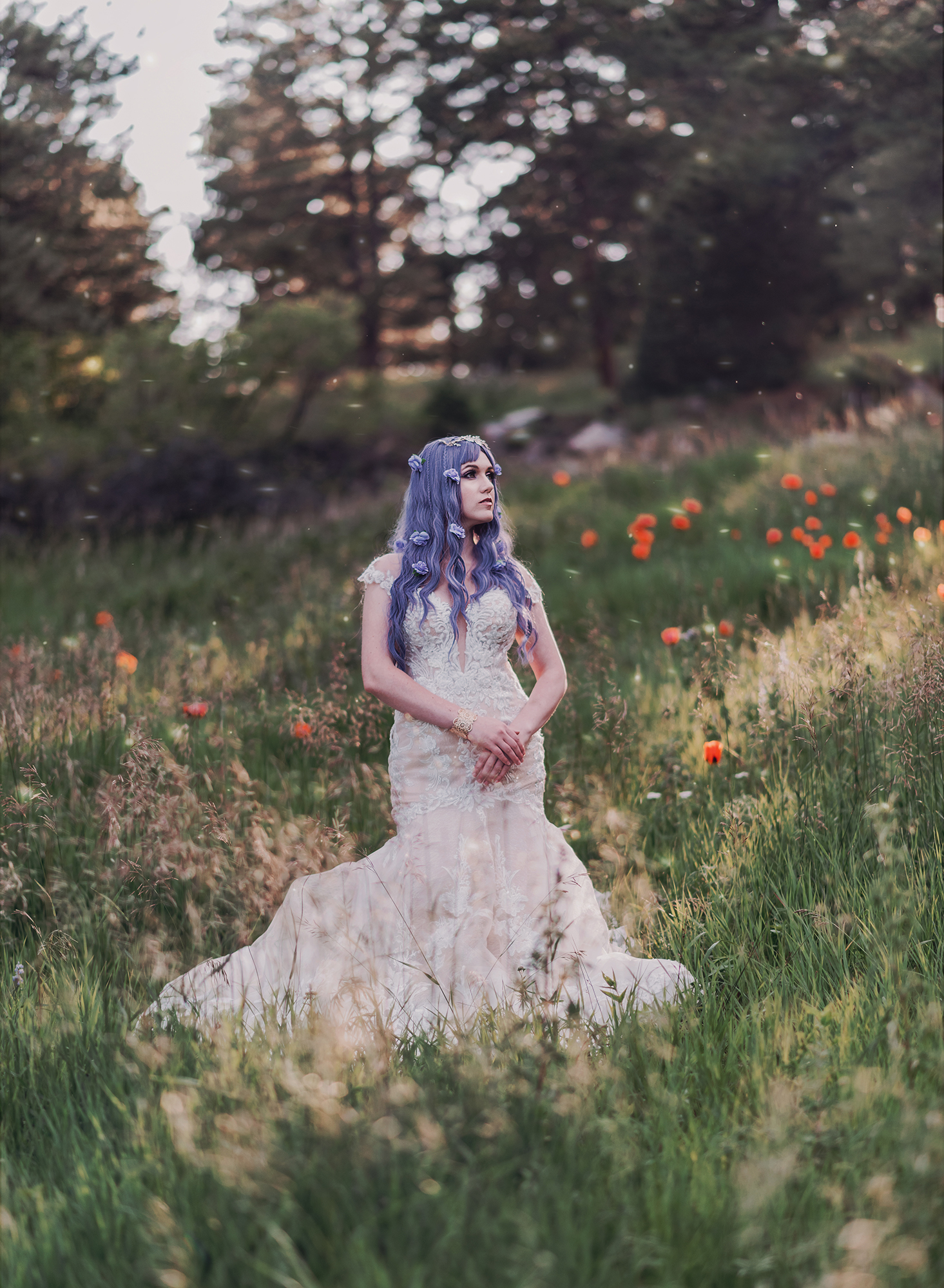 Fantasy bridal portrait of a woman with purple hair and wearing a wedding dress in a field of wildflowers in a woodland area in Boulder Colorado by Kendra Colleen Photography.