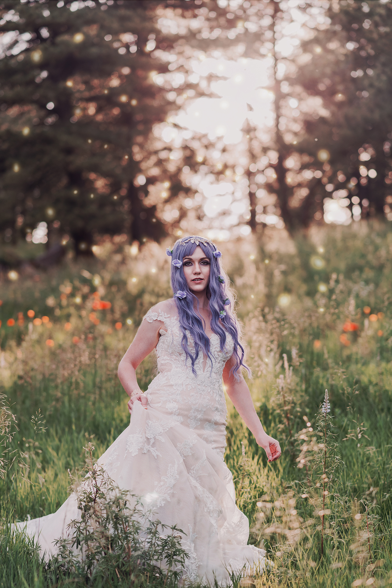 Kendra Colleen Photography takes a fantasy bridal portrait of a woman with purple hair, wearing a white dress, standing in a field of wildflowers in the woods of Boulder Colorado.