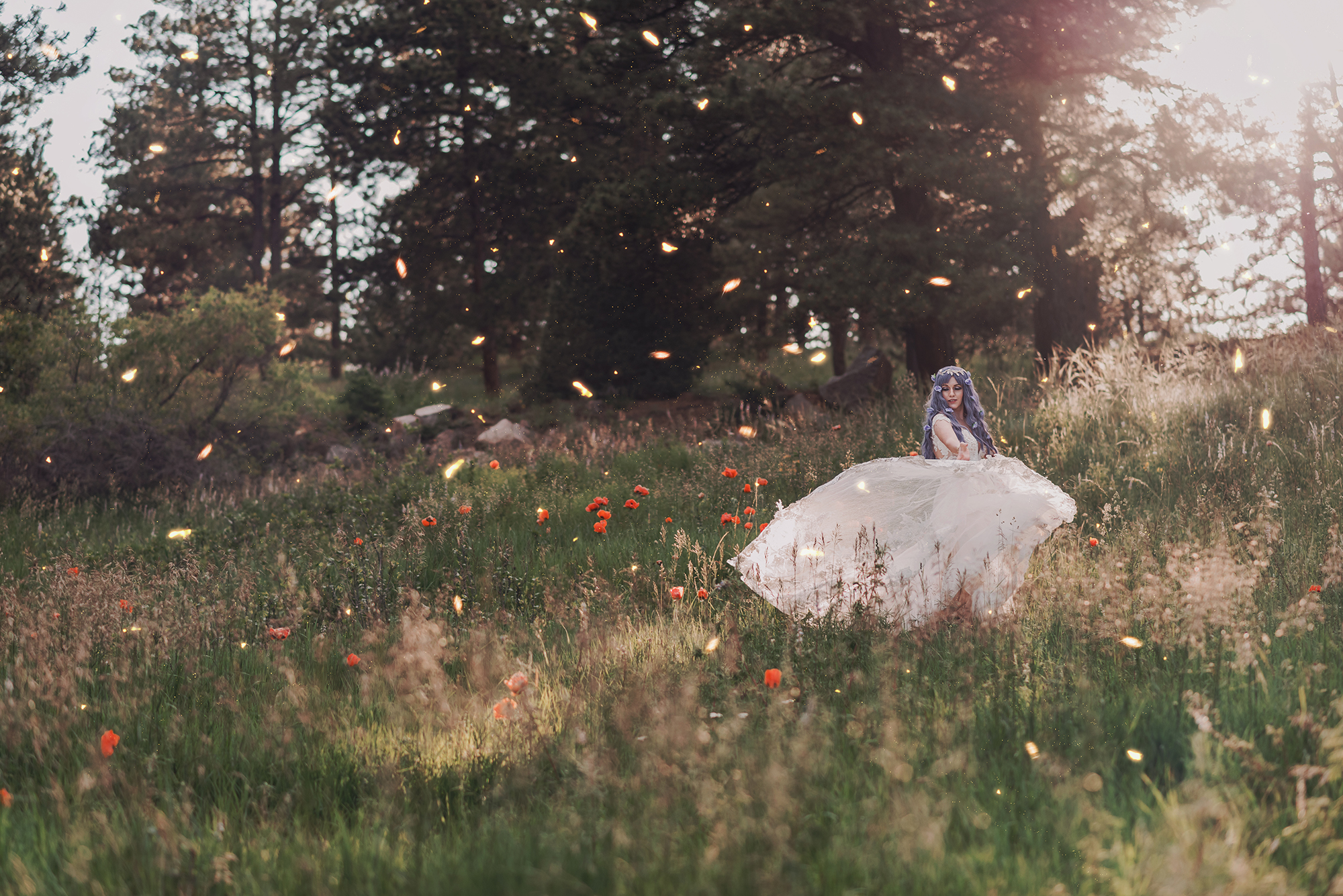 Kendra Colleen Photography takes fantasy bridal photo of a woman with purple hair spinning in a wedding dress in a field of wildflowers in Boulder Colorado.