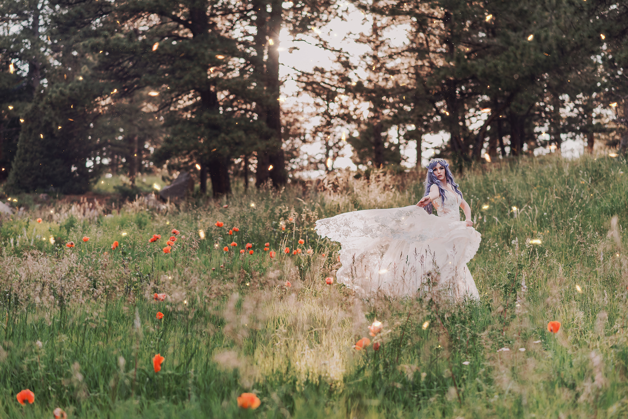 A woman who has purple hair spins in a white dress through a field of wildflowers in the woods of Boulder Colorado for a fantasy bridal photo by Kendra Colleen Photography