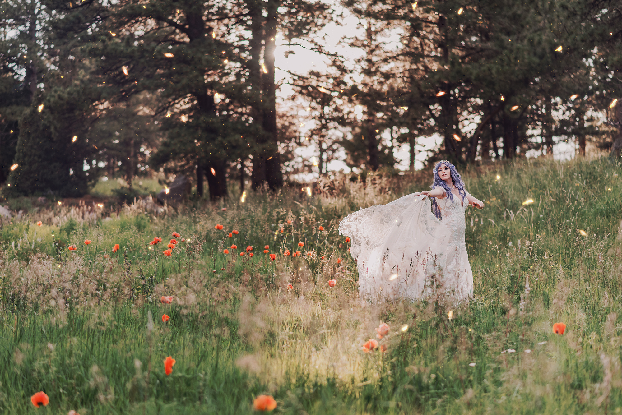 Kendra Colleen Photography takes a fantasy photo of a woman with purple hair spinning in through the woods in a field of wildflowers in Boulder Colorado