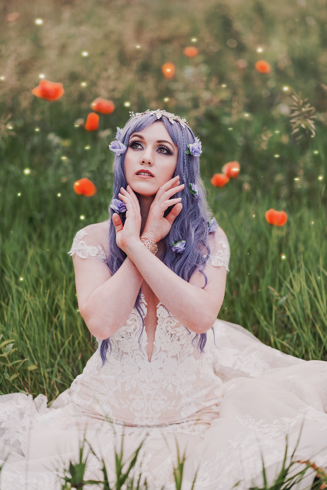 A woman with purple hair and wearing a white dress poses for a fantasy photo taken by Kendra Colleen Photography in a field of wildflowers in Boulder Colorado.