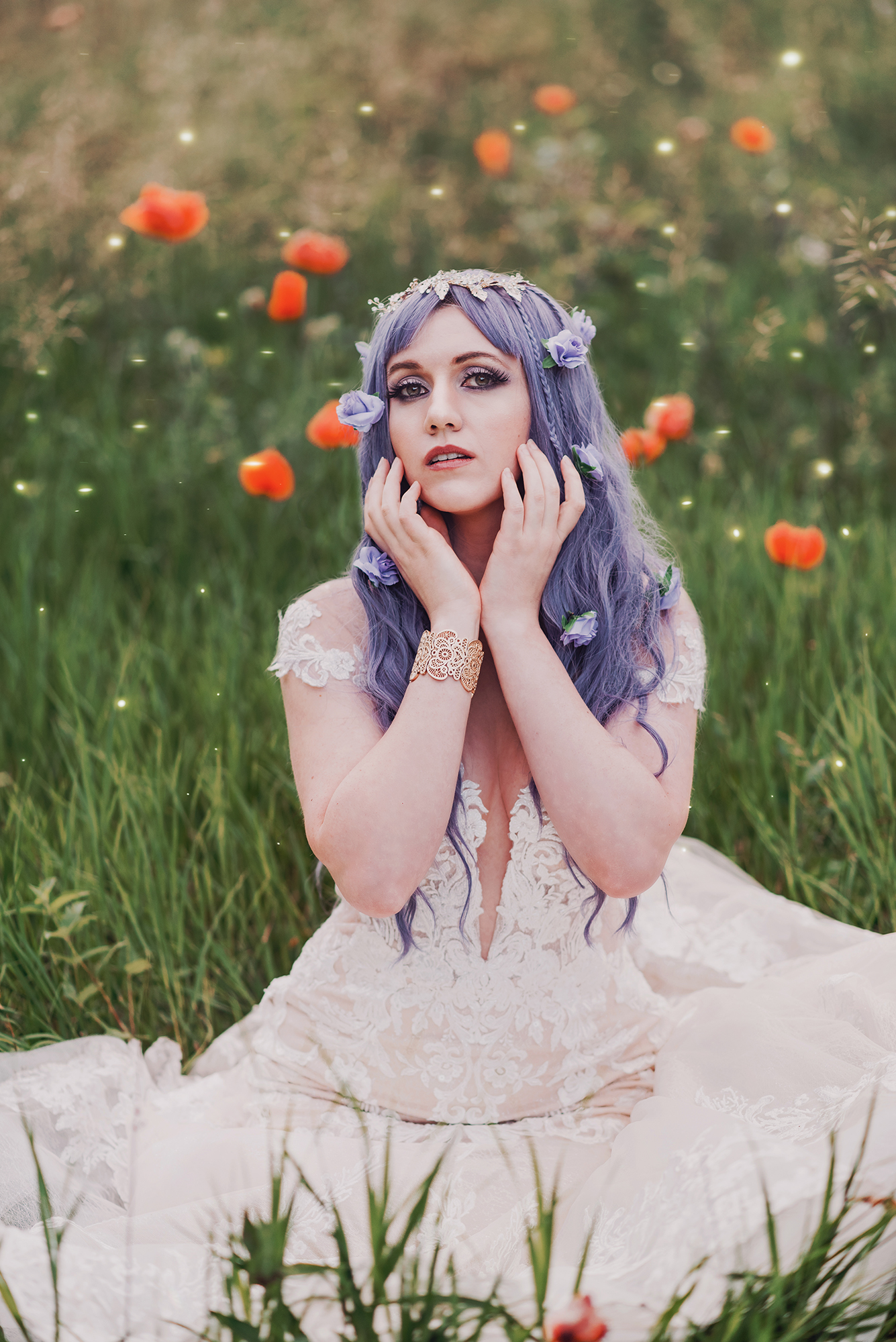 A woman in a white dress with lavender hair sits in a grassy field with red flowers in the background.